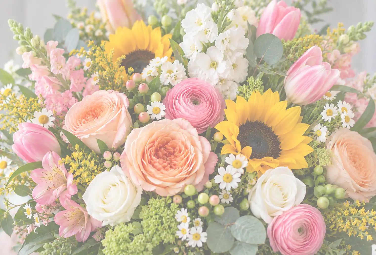 Close-up of a vibrant floral arrangement featuring peach roses, pink ranunculus, yellow sunflowers, 
                  pink tulips, white flowers, daisies, green berries, and lush greenery in Norwich, Connecticut