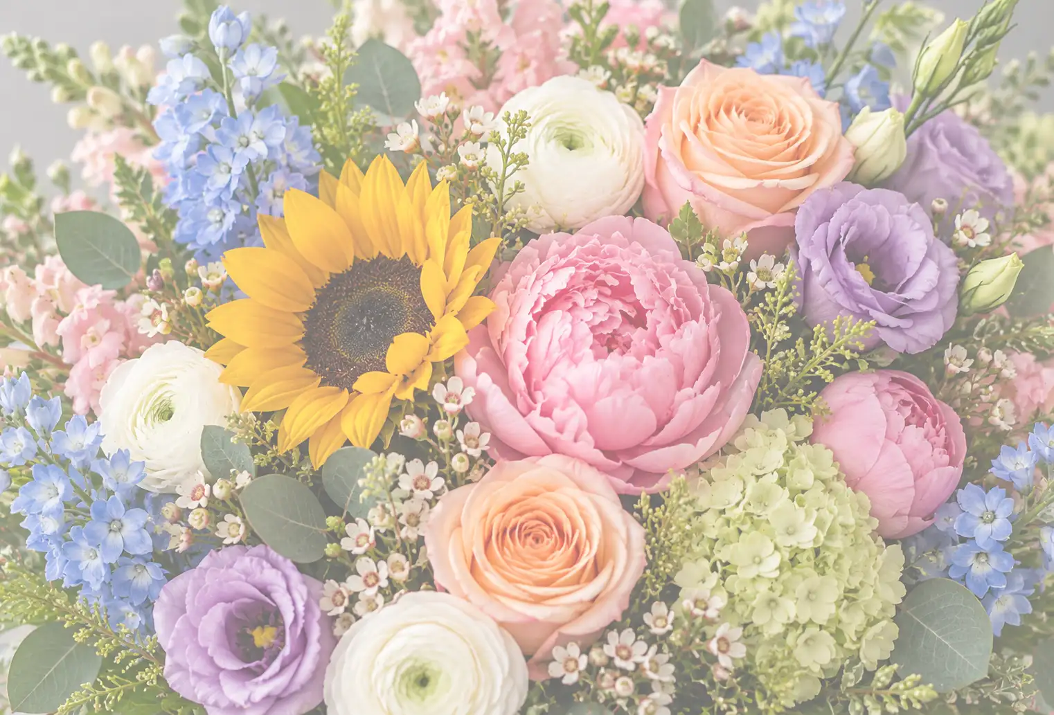 Colorful close-up bouquet featuring pink peonies, peach roses, yellow sunflowers, white ranunculus, purple lisianthus, blue delphinium, green hydrangeas, delicate filler flowers, and eucalyptus foliage in Old Saybrook, Connecticut